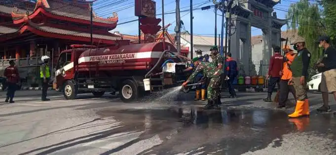 Personel Kodim 0705/ Magelang bersama petugas Satpol PP, pemadam kebakaran dan lainnya melakukan pembersihan abu vulkanik di jalan utama Kota Magelang, setelah terjadi hujan abu akibat erupsi Gunung Merapi yang terjadi pada Sabtu ( 11/3/2023). Foto: W. Cahyono